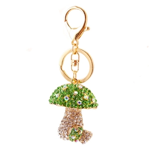 Sparkling green rhinestone mushroom keychain with gold plating on a white background