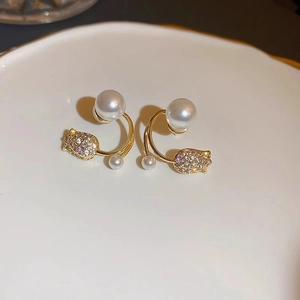 Detail of golden tulip earrings with lustrous pearls and sparkling crystal pavé