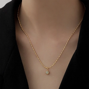 Vintage gold necklace featuring a beaded chain and a round green aventurine pendant