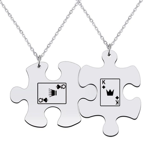 Detail of silver stainless steel puzzle couple necklaces with Queen and King card icons