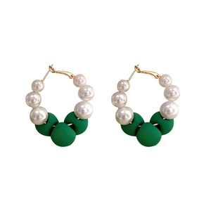 Elegant gold hoop earrings with white pearls and dark green beads on a white background