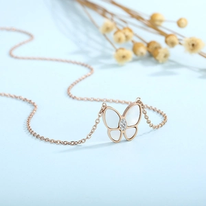 Detailed view of rose gold butterfly necklace with white shell inlay and zircon accents
