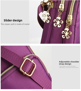 Detail of purple nylon crossbody bag with golden flower zippers and adjustable strap