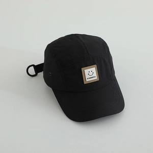 Close-up of black breathable outdoor kids hat with a square kindness smiley face patch