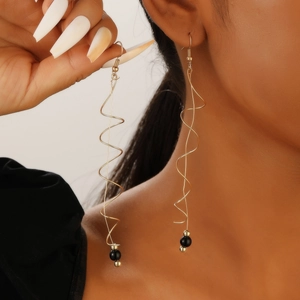 Long golden spiral earrings with dynamic wave design and black bead accents for women
