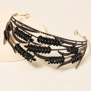 Close-up of golden crown with black gemstones and intricate wheat ear design