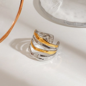Irregular wave-shaped layered ring in mixed silver and gold tones with hammered texture