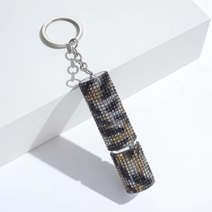 Detailed macro view of a rhinestone-studded cylindrical keychain with a metallic ring