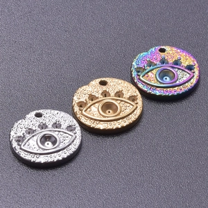 Detailed macro of stainless steel evil eye pendants in silver, gold, and rainbow finishes