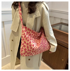 Magenta leopard canvas hobo bag styled on shoulder over light trench coat detail