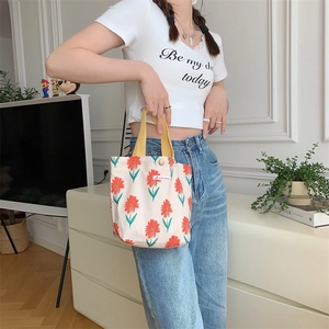 Borsa in tela a fiori con stampa di margherite rosse mostrata in un contesto lifestyle