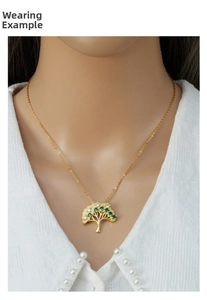 Detail of life tree pendant with green and white zircons on a gold necklace
