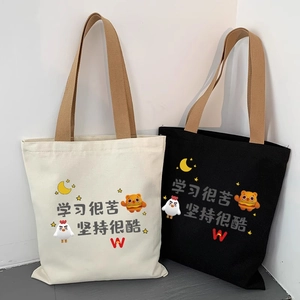 Detail of canvas tote bags in cream and black featuring motivational Chinese text prints