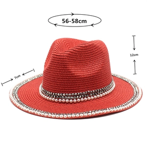 Detail of red straw jazz hat with pearl embellishments and metal studs, 56-58cm size info