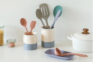 Silicone cooking utensils set in modern ceramic organizers on a clean kitchen counter