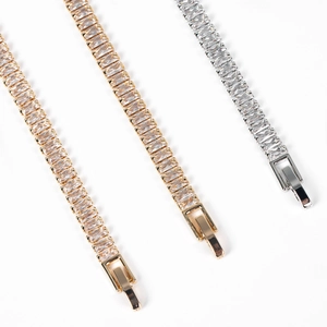Macro detail of gold and silver tennis bracelets with baguette cut cubic zirconia