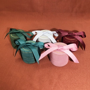 Macro view of velvet jewelry boxes featuring ribbon bows and gold stitching details