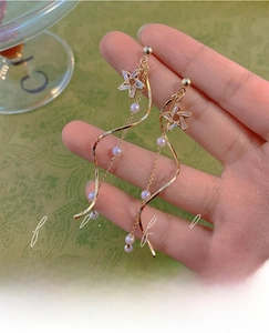 Detail of s925 silver star pearl tassel earrings with gold-finish spiral line design
