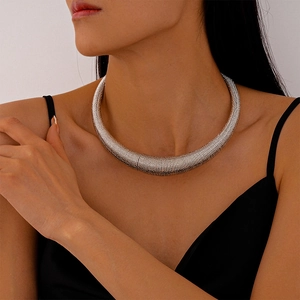 Macro detail of silver spiral texture on a thick metallic choker for women