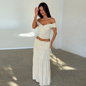 Detail of a beige polka dot two-piece set with V-neck twist top and tiered maxi skirt