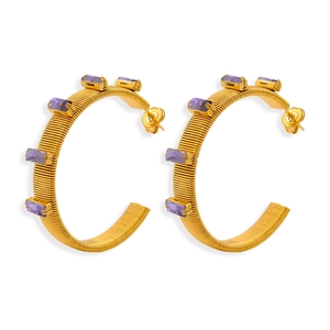 Detail view of gold C-hoop earrings with spiral texture and purple rectangle gemstones