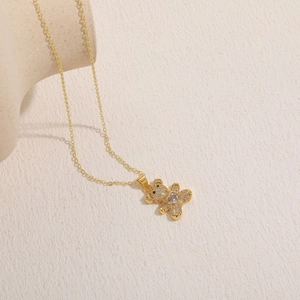 Close-up of golden bear necklace with heart zircon stone and pavé setting details