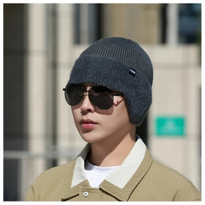 Détail d'un bonnet en tricot gris foncé avec cache-oreilles en polaire et étiquette