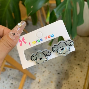 Detail of gray cartoon dog earrings with jelly texture on white display card