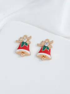 Detailed macro view of red enamel bell pendants with green holly and golden bow