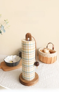 Vertical solid wood tissue holder with thick round base and handle in cozy kitchen setting