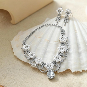 Detail view of flower-shaped faux pearl necklace and teardrop rhinestone pendant set
