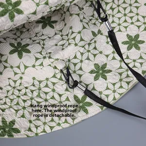 Détail de la corde coupe-vent amovible avec crochet métallique sur un chapeau floral