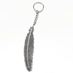 Detailed view of a silver alloy feather keychain with intricate textures on white background
