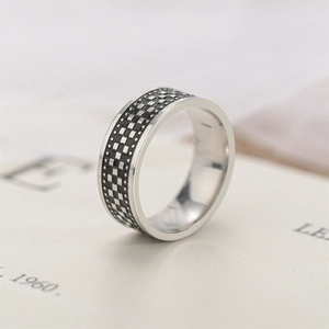 Detailed view of men's vintage titanium steel ring with textured black checkered pattern