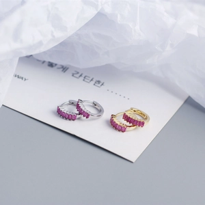 Close-up of S925 silver and gold huggie earrings with rectangular red zircon stones