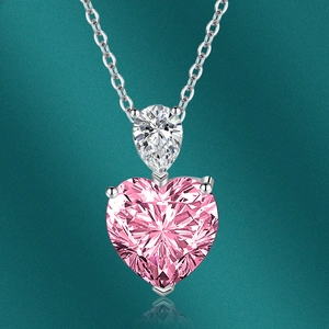 Détail macro d'un collier en argent avec pierre en cœur rose et gemme en forme de poire