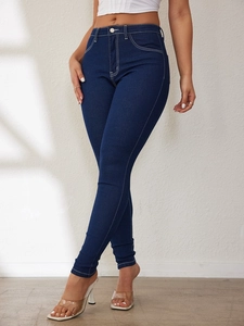 Detail of high-waist slim fit dark blue jeans with contrasting white stitching for women
