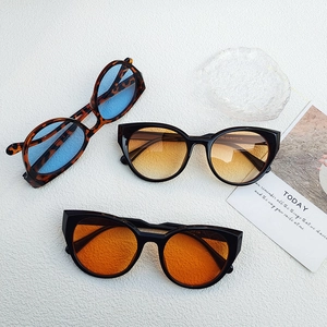 Flat lay of cat-eye sunglasses in tortoiseshell and black with vibrant colored lenses
