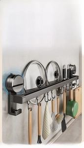 Wall-mounted kitchen rack with vacuum suction, hooks, and slots for knives and lids