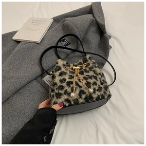 Detailed view of leopard print faux fur bucket bag with pearl and gold chain drawstring