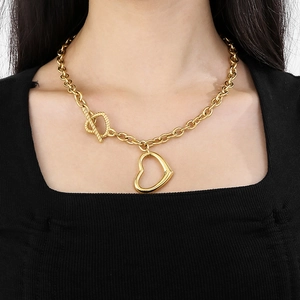 Detailed view of women's gold hollow heart necklace with chic OT toggle clasp on model