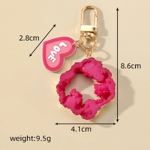 Detailed view of pink resin heart keychain with dimensions 8.6cm and gold ring