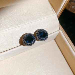 Macro shot of vintage round studs with dark blue gemstone and textured black bead trim