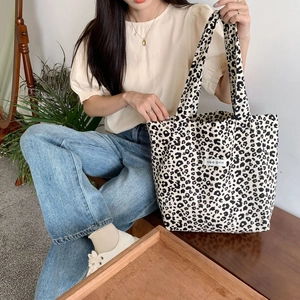 Detailed view of leopard print canvas tote bag with Korean label on a model