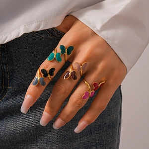 Close-up of vibrant butterfly rings with colorful enamel on a gold-tone band