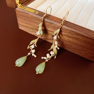 Detail of lily of the valley earrings with green leaf and resin water drop pendant