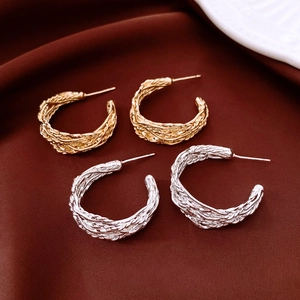 Vue détaillée des boucles d'oreilles en C plaquées or 18 carats avec texture métallique