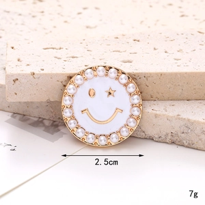 Detail of 2.5cm smiley face shoe charm with pearls and star eye on stone background