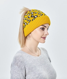 Détail du bonnet en tricot imprimé léopard jaune avec ouverture pour queue de cheval haute