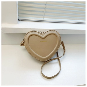 Dettaglio di una borsa a tracolla beige a forma di cuore con stampa dorata sulla pelle